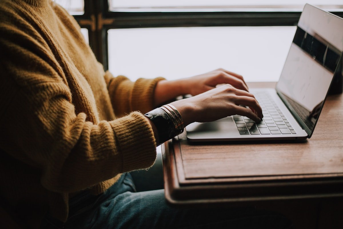 Close-up of hands typing on a laptop keyboard