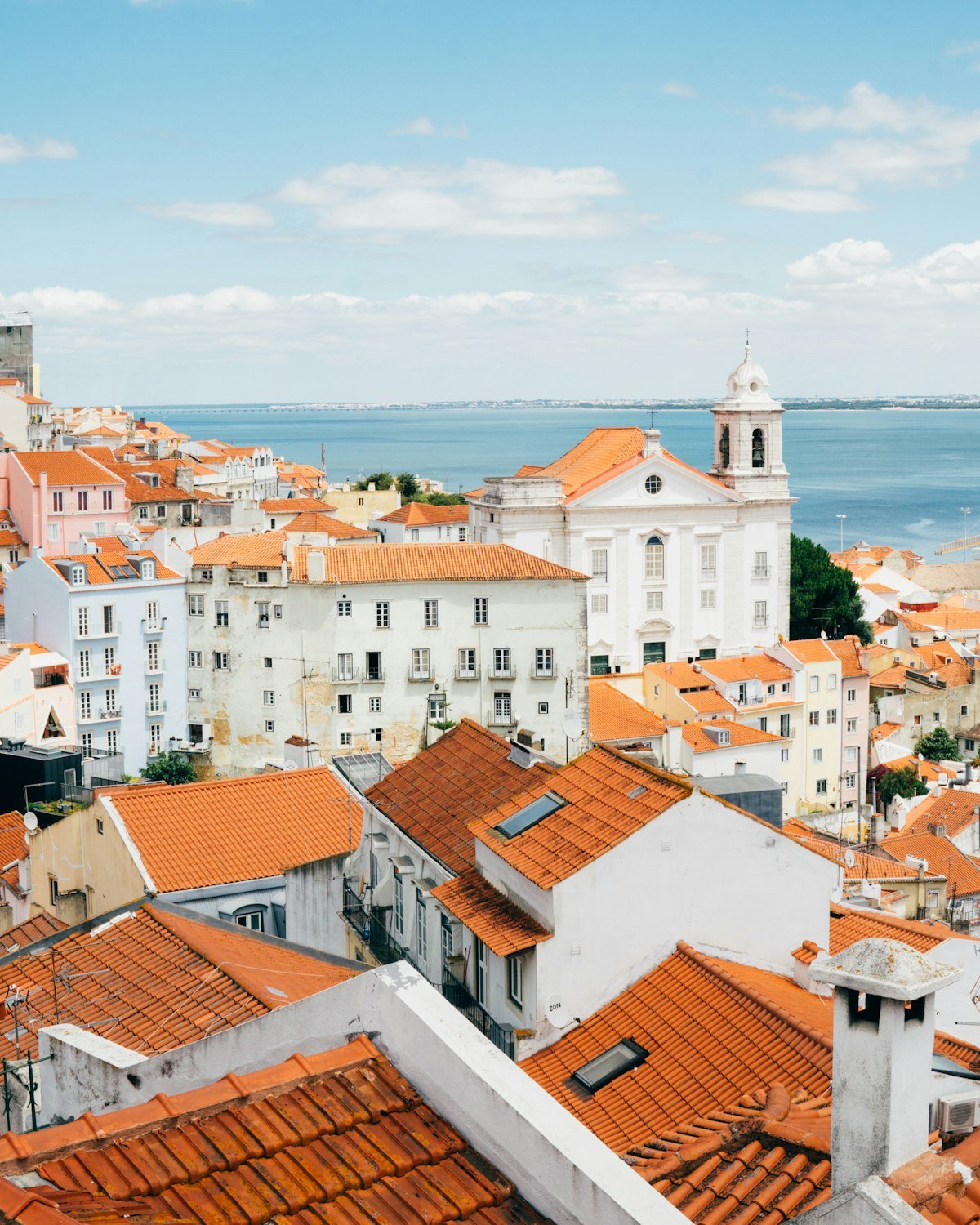 Terracotta rooftops of Lisbon's Alfama district overlooking the Tagus river