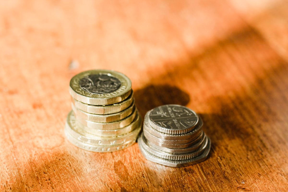 Stacks of British pound coins on a wooden surface